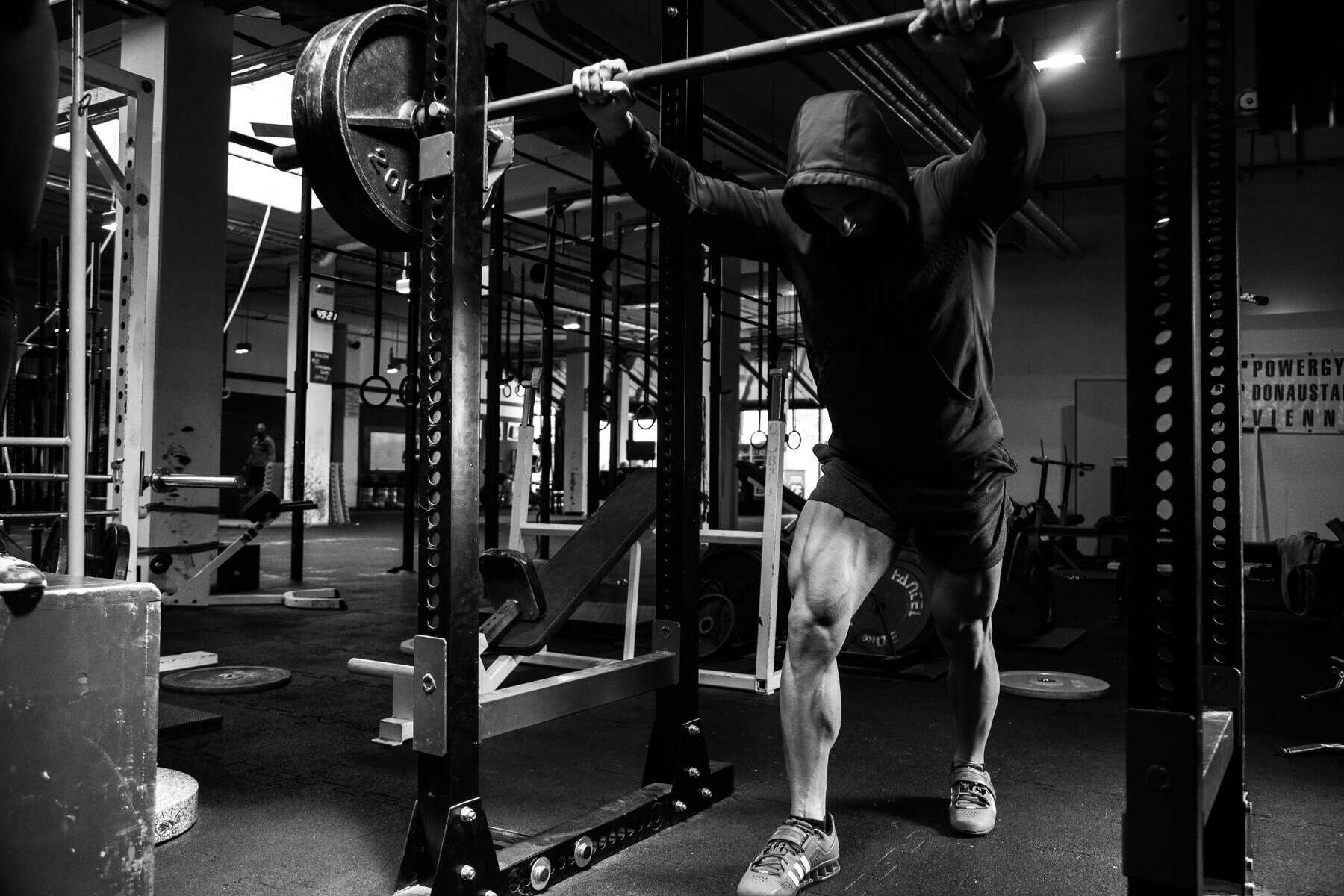 Man lifting heavy weights at gym for strength.